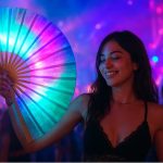 Realistic photo of a young woman at a vibrant 2025 music festival holding a glowing rave fan, surrounded by colorful neon lights and a lively dancing crowd